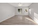 Bright living room with grey walls, light wood floors, and a ceiling fan at 711 S Pearl St, Deland, FL 32720