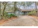Light blue home with large driveway and surrounded by trees at 855 E Church St, Deland, FL 32724