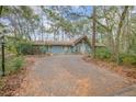 Quaint blue house with a brick driveway and lush landscaping at 855 E Church St, Deland, FL 32724