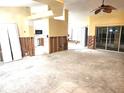 Open-concept living room and kitchen area with ceiling fan and sliding glass doors at 166 Deskin Dr, South Daytona, FL 32119