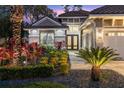 Elegant home exterior with stone accents and lush tropical landscaping at 437 Harbour Town Ln, Ormond Beach, FL 32174