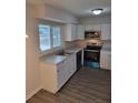 Modern kitchen with white cabinets, stainless steel appliances, and gray countertops at 525 E Roberts St, Orange City, FL 32763