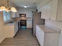 Modern kitchen with white cabinets, stainless steel appliances, and gray countertops at 525 E Roberts St, Orange City, FL 32763