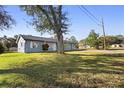 Newly painted home with green lawn and large tree in front at 1911 S Palomar Dr, Deltona, FL 32738