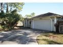 Light-green house exterior with a two-car garage and a long driveway at 2703 Silver Palm Dr, Edgewater, FL 32141