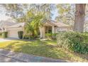 One story house with a beige exterior, brown roof and palm trees at 32543 Crystal Breeze Ln, Leesburg, FL 34788