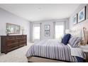 Spacious bedroom with striped bedding and large windows at 1235 Tank Trl, Haines City, FL 33844