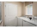 Functional laundry room with washer, dryer, and storage at 3022 Ruby Falls Dr, Deland, FL 32724