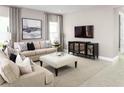 Living room featuring beige sofas, a large TV, and a stylish media cabinet at 5706 Freshwater Canyon Dr, St Cloud, FL 34771