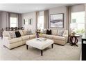Spacious living room with beige sofas, patterned pillows, and a large art piece at 5706 Freshwater Canyon Dr, St Cloud, FL 34771