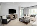 Spacious living room featuring a sofa, armchair, and large TV at 360 Crossings Ave, St Cloud, FL 34771
