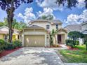 Two-story house with a beige exterior, two-car garage, and manicured lawn at 107 Littleton Cir, Deland, FL 32724