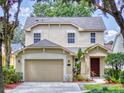 Two-story house with a beige exterior, two-car garage, and manicured lawn at 107 Littleton Cir, Deland, FL 32724