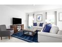 Bright and airy living room with a sofa, rug, and large windows at 1641 Laia Rd, Haines City, FL 33844