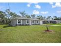 Newly constructed single-story house with gray exterior and landscaping at 77 Redwood Rd, Ocala, FL 34472