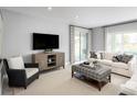 Living room featuring a comfy couch, ottoman, and large window at 1299 Whispering Ln, Minneola, FL 34715