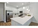 Modern white kitchen with stainless steel appliances and an island at 6923 Five Oaks Dr, St Cloud, FL 34773