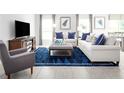 Bright living room features comfy sofas, a large TV, and a stylish blue rug at 1337 Laramie Way, Haines City, FL 33844