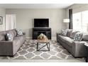 Spacious living room featuring two gray sofas, a coffee table, and patterned rug at 322 Biltmore Blvd, Dundee, FL 33838