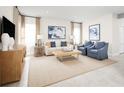 Living room featuring a white sofa, blue armchairs, and a wooden entertainment center at 265 Eagle Harbor Way, Daytona Beach, FL 32124