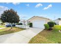 House exterior with driveway, landscaping, and white picket fence at 1052 Ridgeville Rd, The Villages, FL 32162