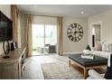 Living area with sliding glass doors leading to a patio, and large clock at 5098 Grand Teton Ct, Deland, FL 32724