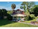 Quaint yellow house with red roof and a front porch at 104 Sunset Way, Fruitland Park, FL 34731
