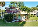 Yellow house with red roof, porch, and well-maintained landscaping at 104 Sunset Way, Fruitland Park, FL 34731
