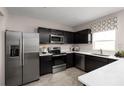Modern kitchen with dark cabinetry, stainless steel appliances, and white countertops at 1653 Laia Rd, Haines City, FL 33844
