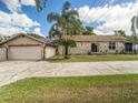 Ranch home with stone exterior, attached garage, and a spacious yard at 1910 E Pollock Rd, Lakeland, FL 33813