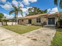 Charming stone house with a new dark blue front door and a walkway at 1910 E Pollock Rd, Lakeland, FL 33813