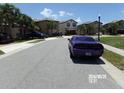 View of the street with parked cars and similar style homes at 5537 Misty Oak Cir, Davenport, FL 33837