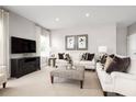 Spacious living room with comfortable sofas, a large TV, and tasteful decor at 10865 Sw 73Rd Ct, Ocala, FL 34476