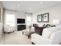 Bright living room featuring white sofas, a large TV, and stylish decor at 10865 Sw 73Rd Ct, Ocala, FL 34476