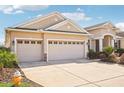 Three-car garage with tan exterior and driveway at 5631 Superior Dr, Lakeland, FL 33805