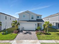 Two-story house with a gray exterior, gray driveway, and landscaping at 2201 Lelani Cir, Davenport, FL 33897