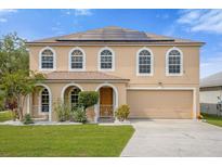 Two-story house with solar panels and arched windows at 11407 Bentry St, Orlando, FL 32824