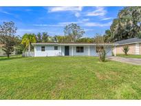 Ranch-style home with light blue exterior and spacious lawn at 186 Poinciana Ln, Deltona, FL 32738