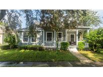 Gray house with white porch and landscaping at 7036 Mapperton Dr, Windermere, FL 34786