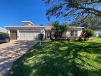 Single-Gathering home with a two-car garage and landscaped yard at 24502 Parlange Ct, Leesburg, FL 34748