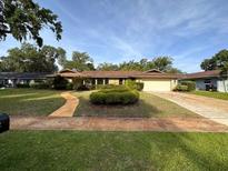 Single-story home with a well-manicured lawn and driveway at 4422 Meadowood St, Orlando, FL 32812