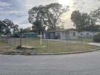 Front exterior view of a single-story home with a fenced yard and a storage shed at 7204 Peyton Pl, Orlando, FL 32818