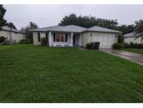 Single-story house with green lawn and attached garage at 6059 Magpie Dr, Lakeland, FL 33809