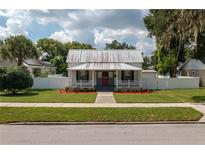 Charming craftsman home with a metal roof, red door, and landscaped yard at 815 E Church St, Bartow, FL 33830