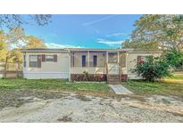 Mobile home exterior features a screened porch and well-maintained lawn at 408 Garrett Ridge Ct, Winter Haven, FL 33880