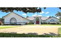 Two-story home with red door and large driveway at 2418 Berkshire Dr, Winter Haven, FL 33884