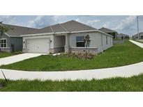 One-story house exterior with stone accents and landscaping at 2561 Mariah Pl, Lake Alfred, FL 33850