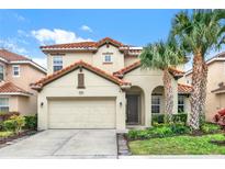 Two-story house with tile roof, attached garage, and landscaped yard at 5240 Oakbourne Ave, Davenport, FL 33837