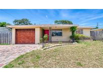 Ranch-style home with brick facade, red garage door, and landscaped yard at 147 Longwood Dr, Ormond Beach, FL 32176