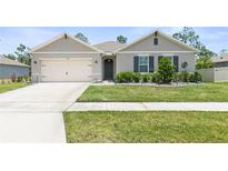 One-story home with neutral siding and a two-car garage at 225 Sunset Point Dr, Ormond Beach, FL 32174